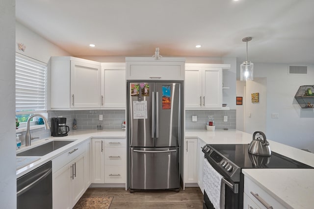 kitchen with pendant lighting, sink, white cabinetry, stainless steel appliances, and dark hardwood / wood-style flooring