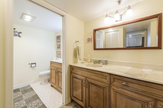 bathroom with vanity, toilet, and a shower with door