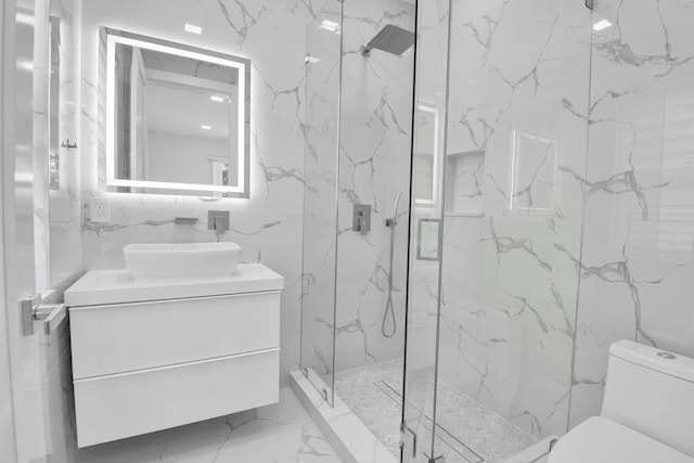 bathroom with tile walls, vanity, toilet, and an enclosed shower