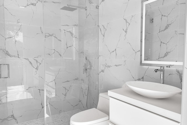 bathroom featuring tile walls, vanity, toilet, and a shower with door