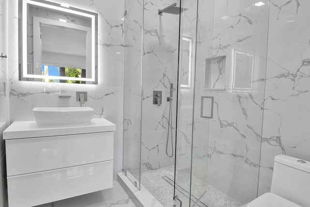 bathroom featuring vanity, tile walls, a shower with shower door, and toilet