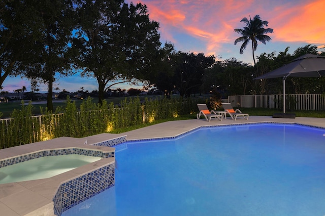 pool at dusk featuring a patio area