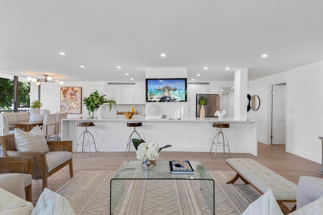 living room featuring an inviting chandelier and light hardwood / wood-style floors