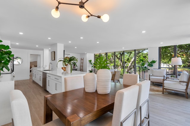 dining area featuring floor to ceiling windows, light wood-type flooring, and sink