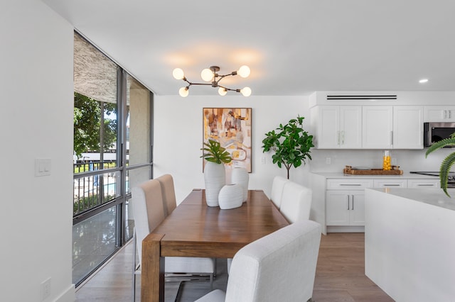 dining space featuring an inviting chandelier, light hardwood / wood-style floors, and expansive windows