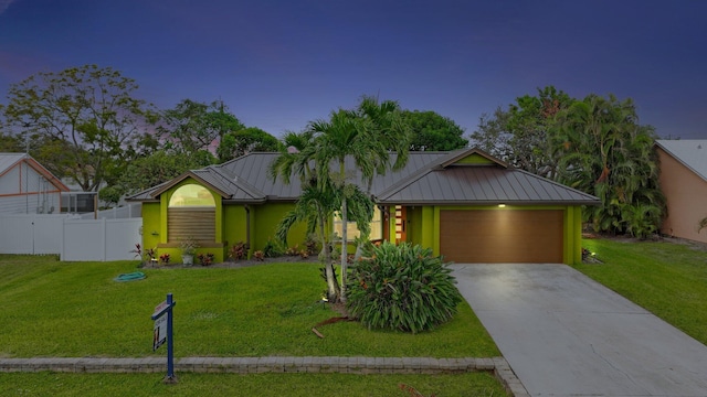 view of front of home with a garage and a lawn