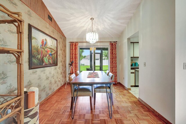 dining area featuring light parquet flooring, lofted ceiling, french doors, and a chandelier