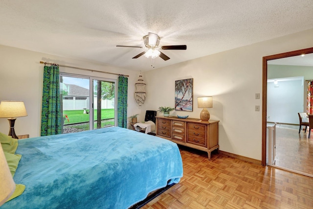 bedroom with access to exterior, a textured ceiling, light parquet flooring, and ceiling fan