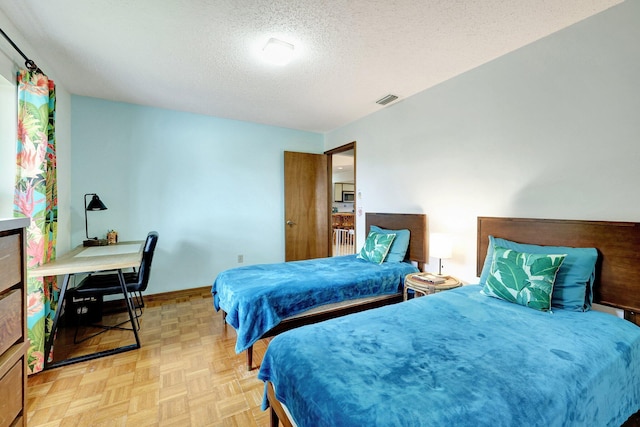 bedroom with a textured ceiling and light parquet flooring