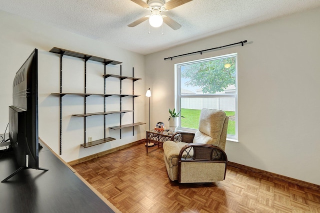 living area with a textured ceiling, light parquet floors, a wealth of natural light, and ceiling fan