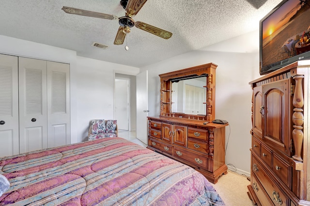 carpeted bedroom with a closet, ceiling fan, and a textured ceiling