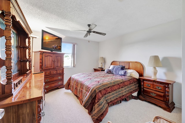 carpeted bedroom featuring a textured ceiling and ceiling fan