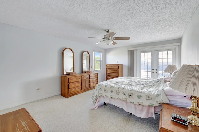 carpeted bedroom featuring a textured ceiling, access to exterior, french doors, and ceiling fan