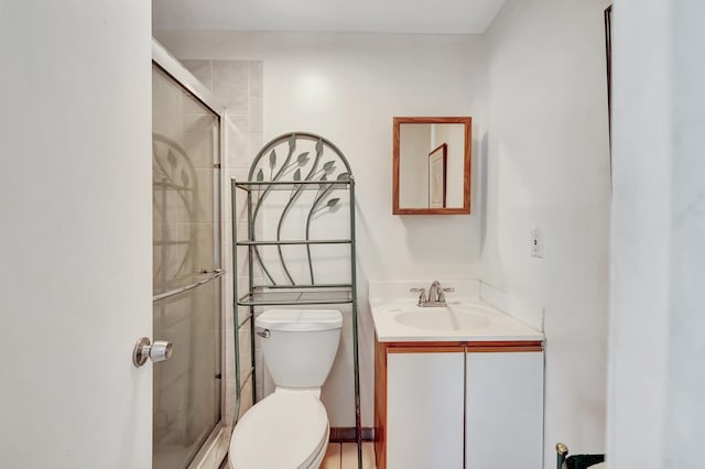 bathroom with toilet, a shower with shower door, and vanity