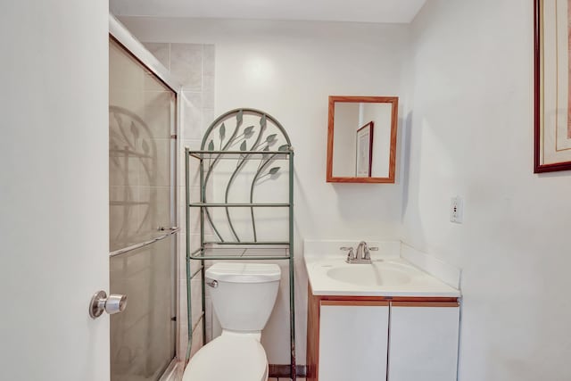 bathroom featuring toilet, an enclosed shower, and vanity