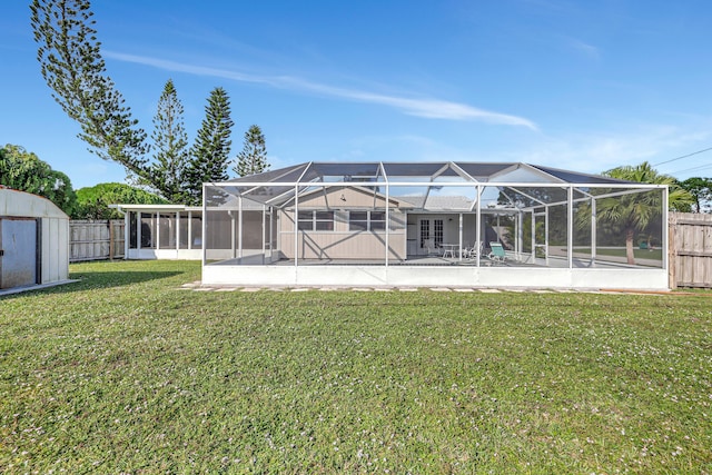 rear view of property with a shed, a patio area, glass enclosure, and a lawn