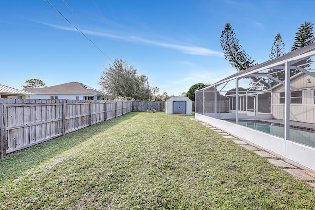 view of yard featuring a lanai, a storage unit, and a fenced in pool