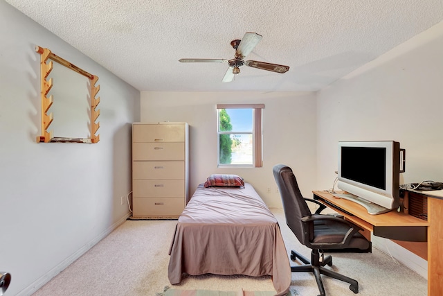 carpeted bedroom featuring ceiling fan and a textured ceiling