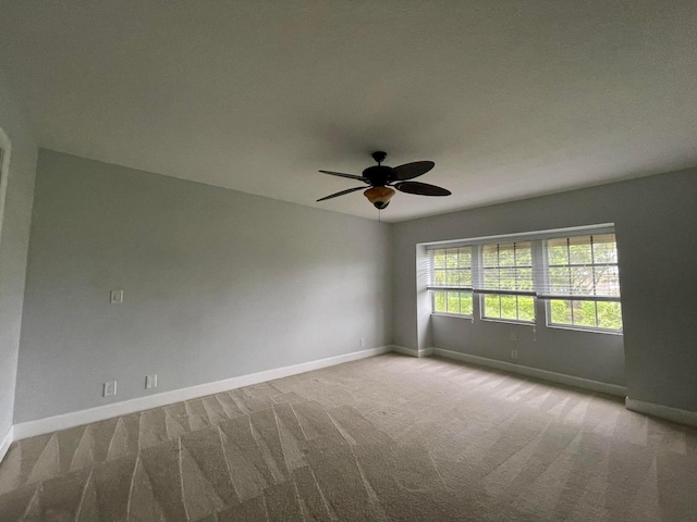 unfurnished room with ceiling fan and light colored carpet