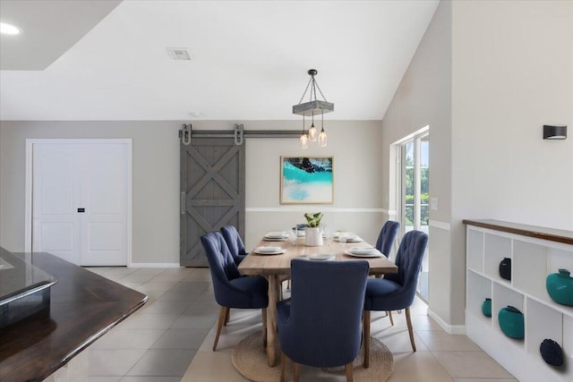 dining area featuring a barn door, lofted ceiling, and light tile patterned floors