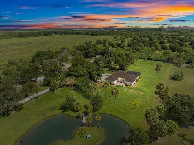 aerial view at dusk featuring a water view and a rural view