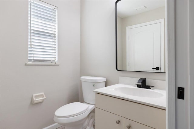 bathroom with plenty of natural light, vanity, and toilet