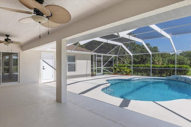 view of swimming pool with glass enclosure, ceiling fan, and a patio