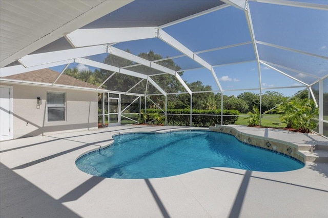 view of swimming pool with glass enclosure and a patio area