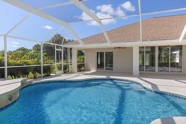 view of swimming pool featuring ceiling fan, a lanai, and a patio area