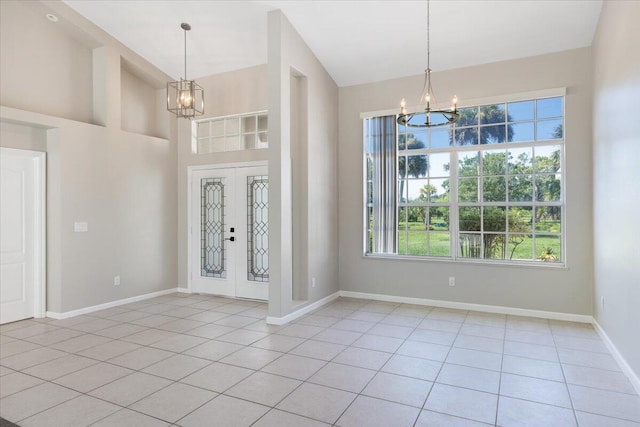 foyer featuring an inviting chandelier, light tile patterned flooring, high vaulted ceiling, and french doors