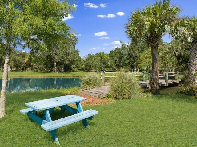 view of community featuring a lawn and a water view