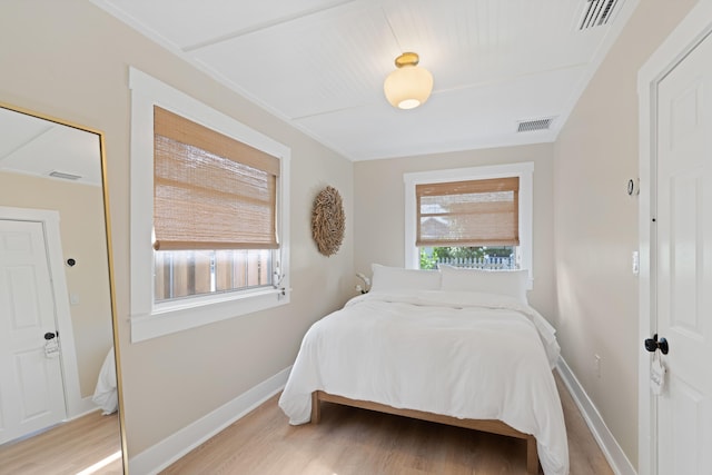 bedroom with light hardwood / wood-style floors and multiple windows