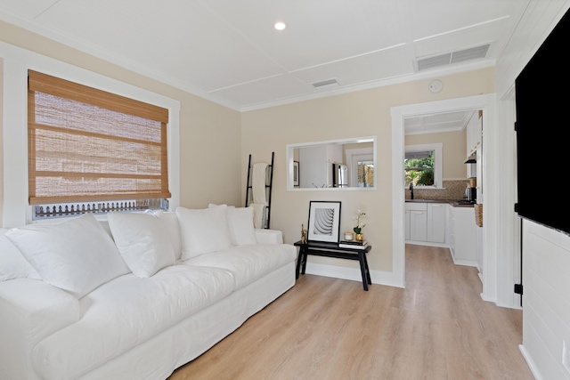 living room with crown molding and light wood-type flooring