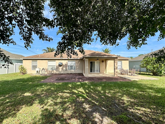 rear view of property with a lawn and a patio area