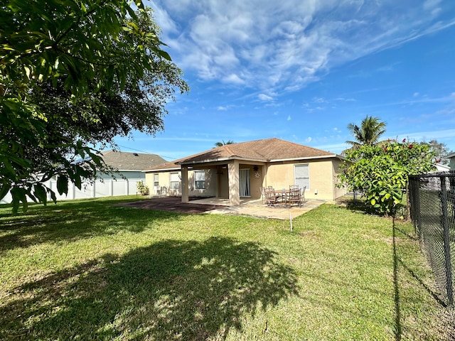 back of house with a patio and a yard