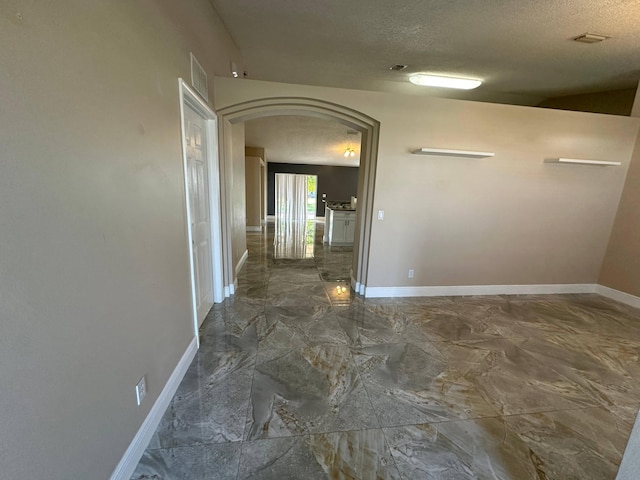 corridor featuring a textured ceiling