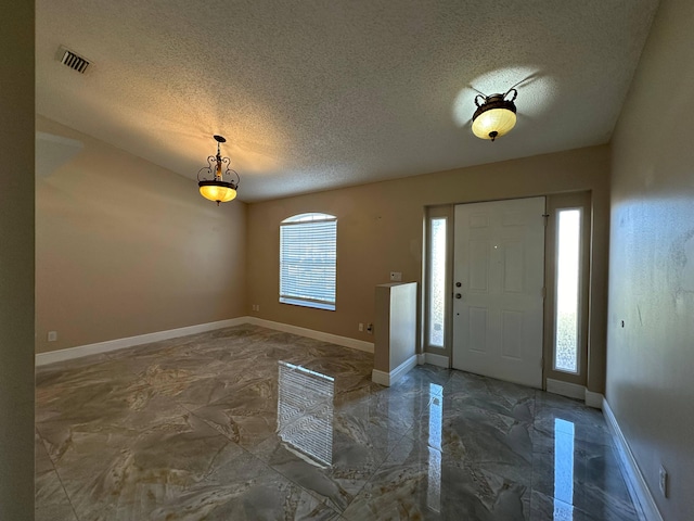 foyer featuring a textured ceiling and plenty of natural light