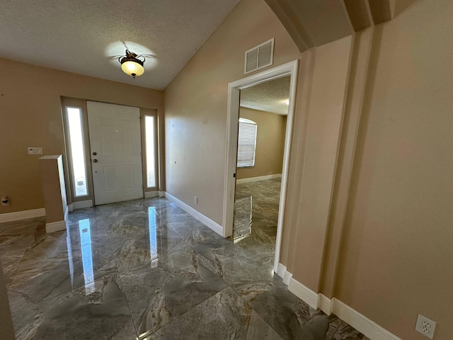 entrance foyer featuring a textured ceiling and vaulted ceiling