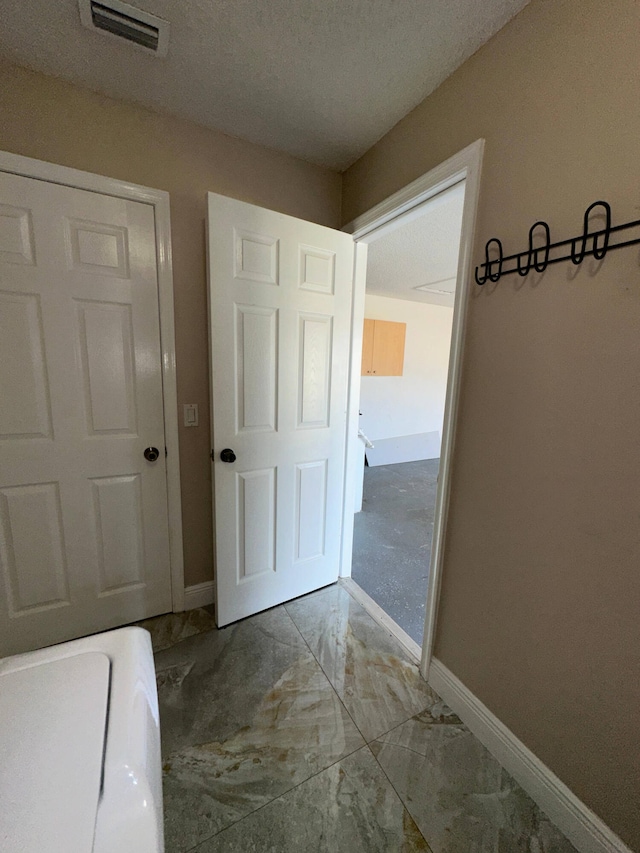 corridor featuring a textured ceiling