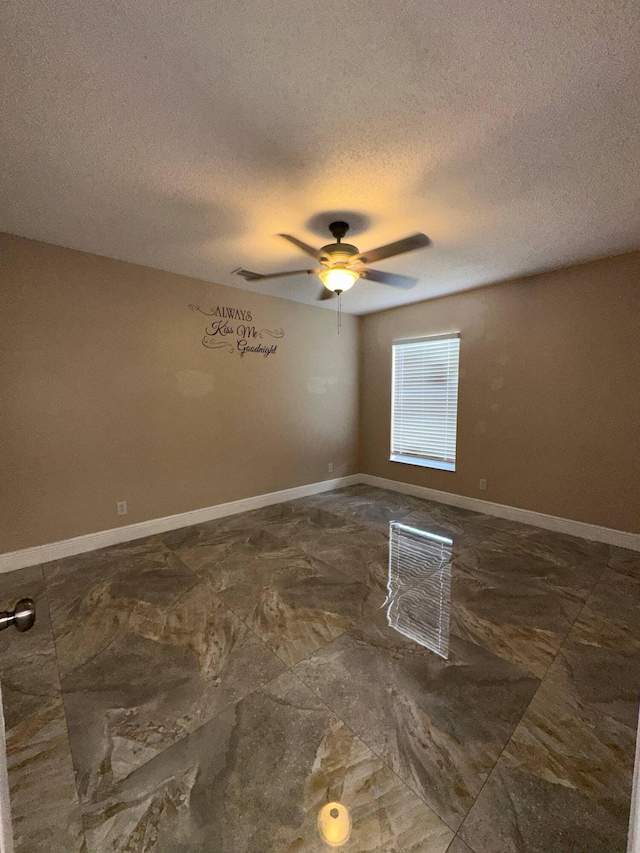 empty room with a textured ceiling and ceiling fan