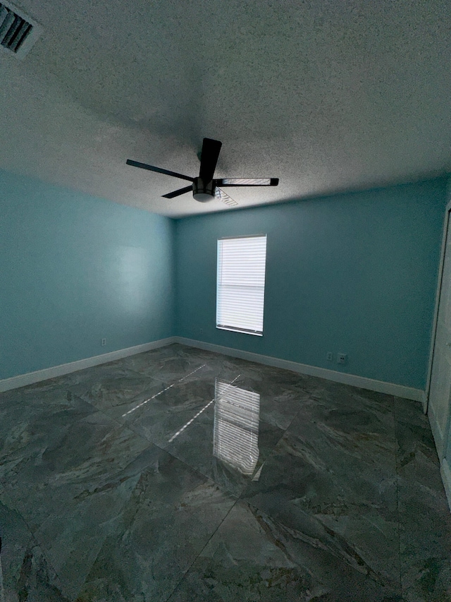 unfurnished room featuring a textured ceiling and ceiling fan