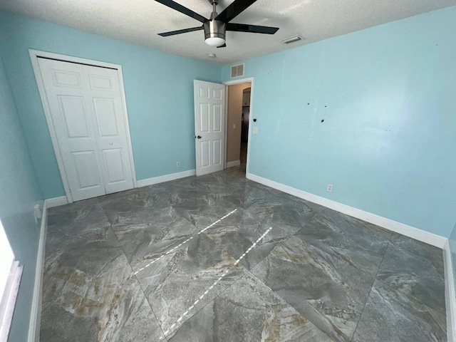 unfurnished bedroom featuring a closet, ceiling fan, and a textured ceiling