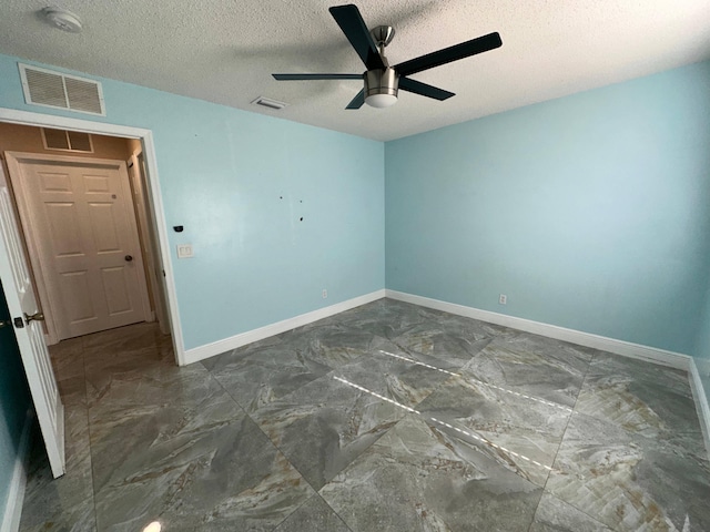 empty room featuring a textured ceiling and ceiling fan