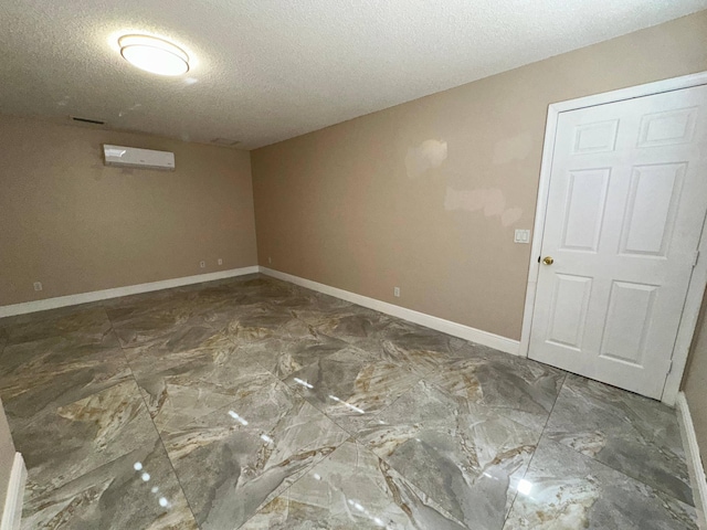 empty room featuring a textured ceiling and an AC wall unit