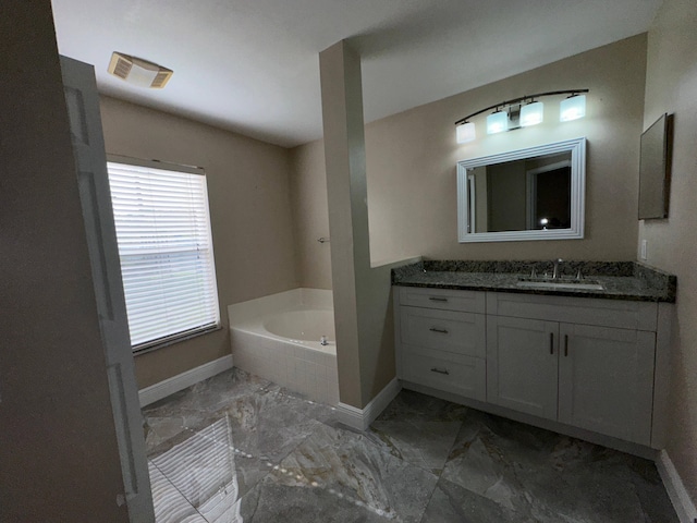 bathroom with vanity and a relaxing tiled tub