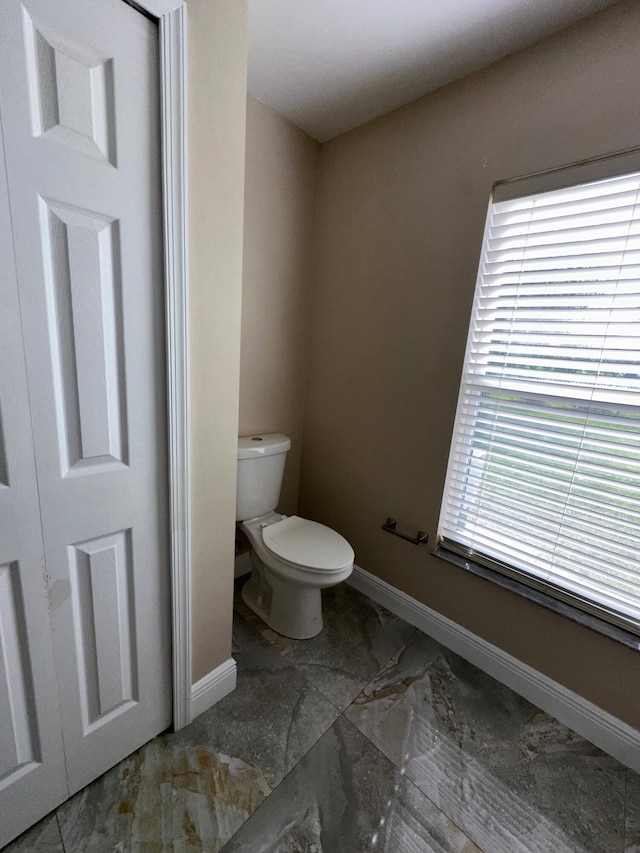 bathroom featuring plenty of natural light and toilet