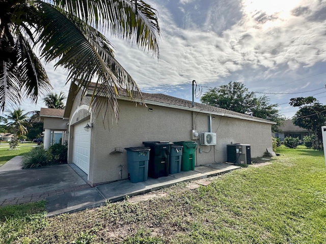 view of property exterior with a garage, a lawn, and central air condition unit