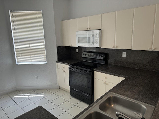 kitchen with light tile patterned flooring, black electric range, and sink