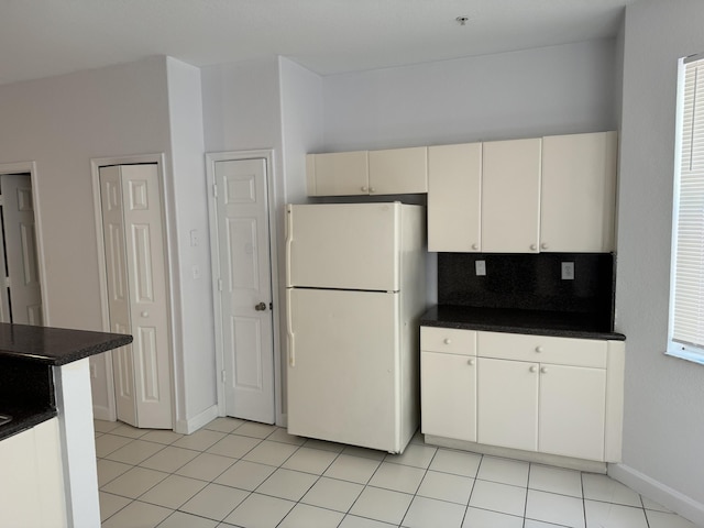 kitchen with decorative backsplash, light tile patterned floors, and white fridge