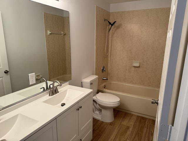 full bathroom featuring tiled shower / bath combo, vanity, and toilet